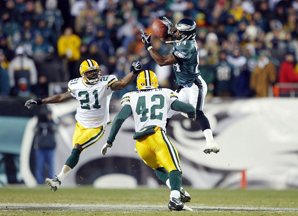 Wide receiver Freddie Mitchell #84 of the Philadelphia Eagles catches a 28-yard catch on defensive backs Jue Bhawoh #21 and Darren Sharper #42 of the Green Bay Packers on the Eagles last posession in the forth quarter during the NFC divisional playoffs on January 11, 2004 at Lincoln Financial Field in Philadelphia, Pennsylvania. The down and distance was fourth and 26.