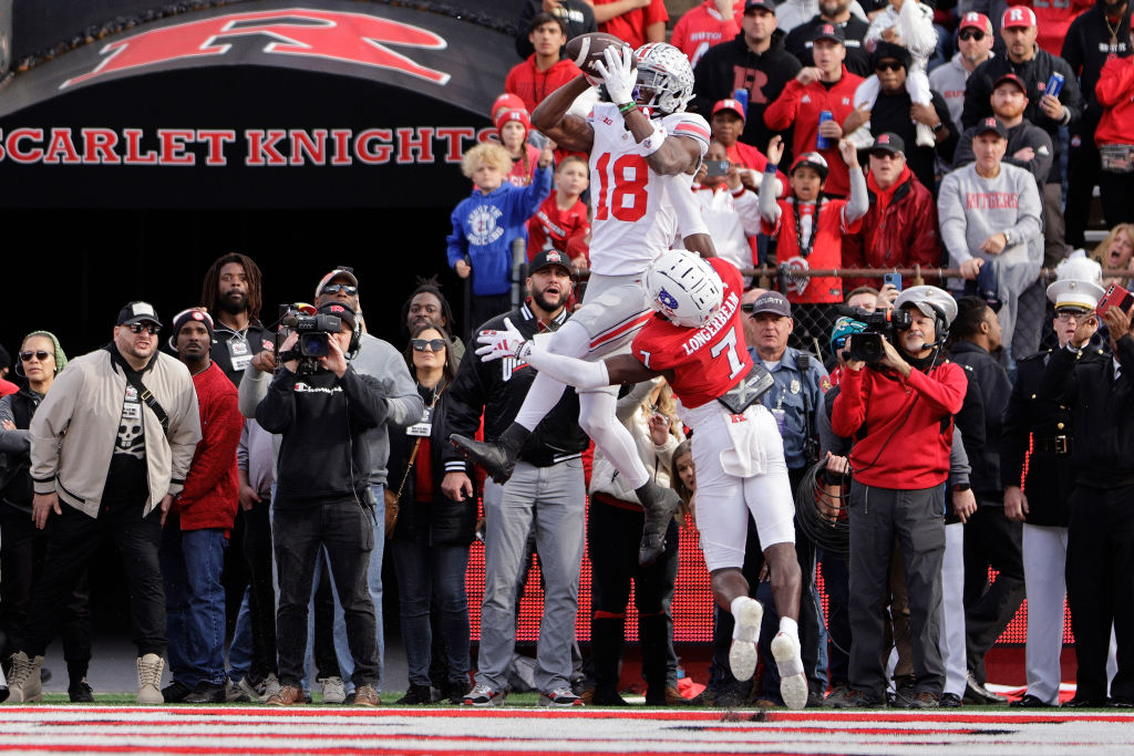 PISCATAWAY, NEW JERSEY - NOVEMBER 4: Wide receiver Marvin Harrison Jr. #18 of the Ohio State Buckeyes jumps over defensive back Robert Longerbeam #7 of the Rutgers Scarlet Knights to make a touchdown catch during the fourth quarter of a college football game at SHI Stadium on November 4, 2023 in Piscataway, New Jersey. Ohio State defeated Rutgers 35-16. 