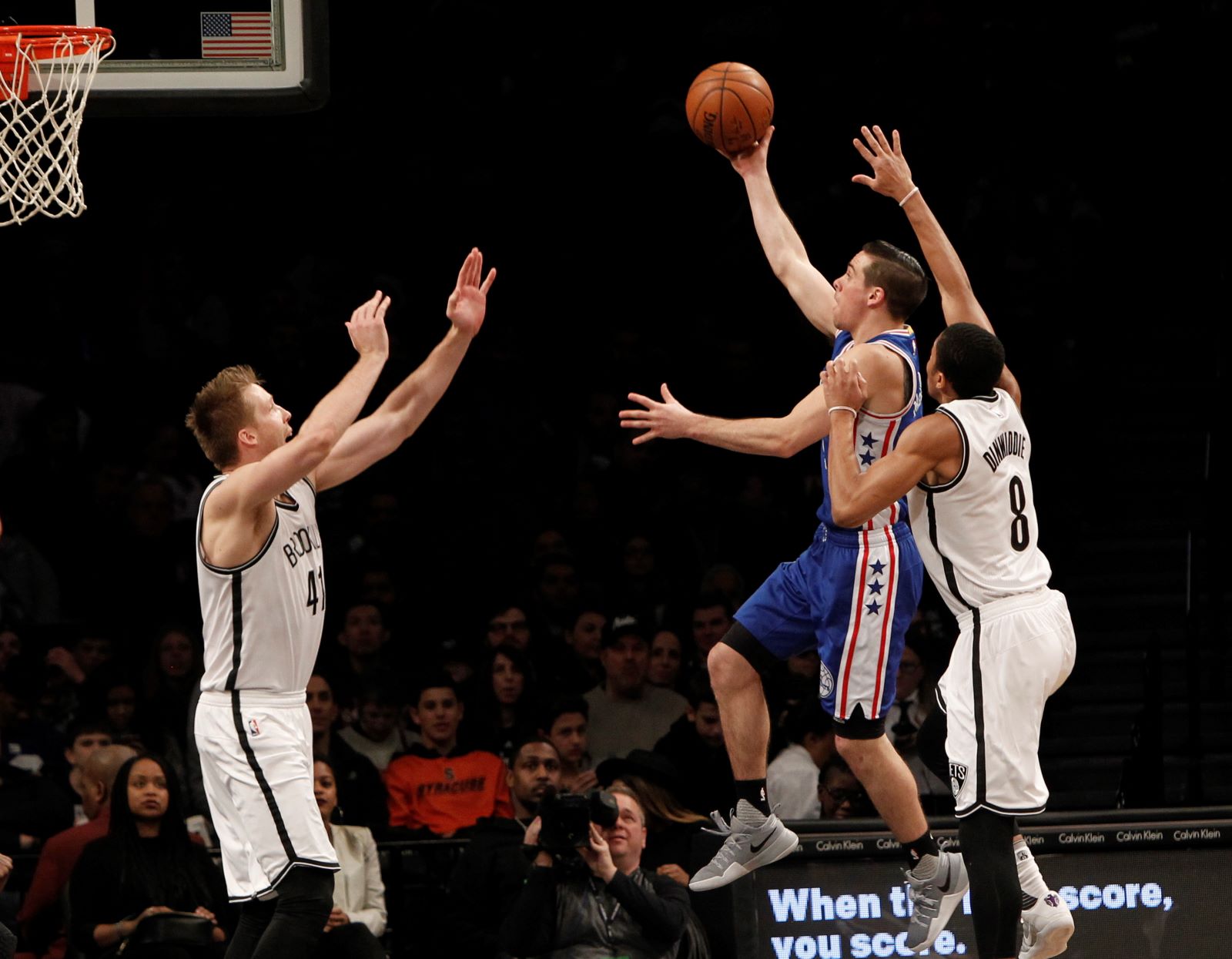 Philadelphia 76ers guard TJ McConnell (1) puts up a shot against Brooklyn Nets center Justin Hamilton (41) and guard Spencer Dinwiddie (8) in the fourth quarter at Barclays Center. Sixers win 105-95. 