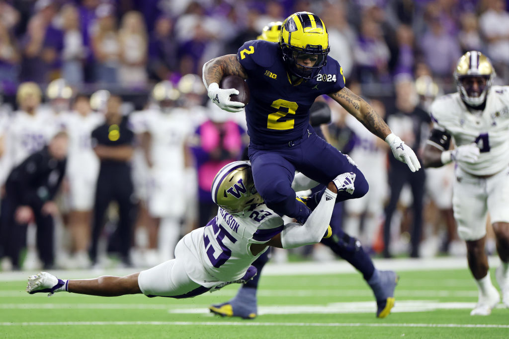 HOUSTON, TEXAS - JANUARY 08: Blake Corum #2 of the Michigan Wolverines runs the ball against Elijah Jackson #25 of the Washington Huskies in the first half during the 2024 CFP National Championship game at NRG Stadium on January 08, 2024 in Houston, Texas. 