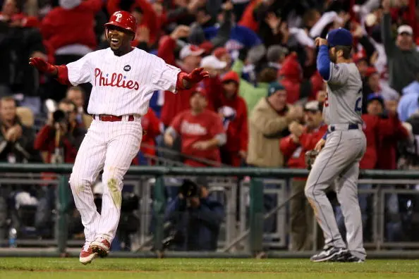 PHILADELPHIA - OCTOBER 19: Jimmy Rollins #11 of the Philadelphia Phillies celebrates after he hit a game-winning walkoff 2-run double to beat the Los Angeles Dodgers 5-4 as Casey Blake #23 of the Dodgers walks off the field dejected in Game Four of the NLCS during the 2009 MLB Playoffs at Citizens Bank Park on October 19, 2009 in Philadelphia, Pennsylvania. 