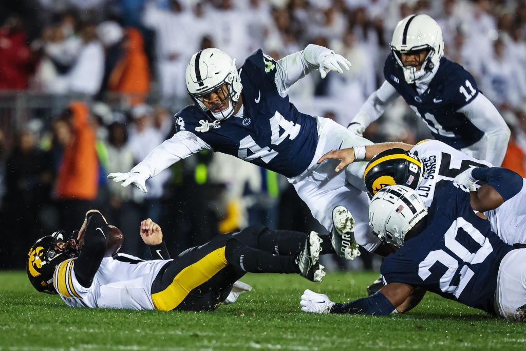 STATE COLLEGE, PA - SEPTEMBER 23: Cade McNamara #12 of the Iowa Hawkeyes is sacked by Chop Robinson #44 and Adisa Isaac #20 of the Penn State Nittany Lions during the first half at Beaver Stadium 
