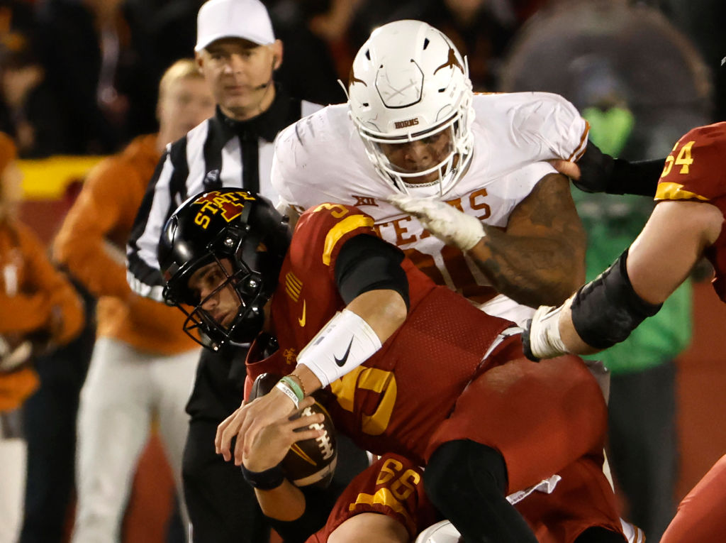 Quarterback Rocco Becht #3 of the Iowa State Cyclones is tackled by defensive lineman Byron Murphy II #90 of the Texas Longhorns in the second half of play at Jack Trice Stadium on November 18, 2023 in Ames, Iowa. The Texas Longhorns won 26-16 over the Iowa State Cyclones. 
