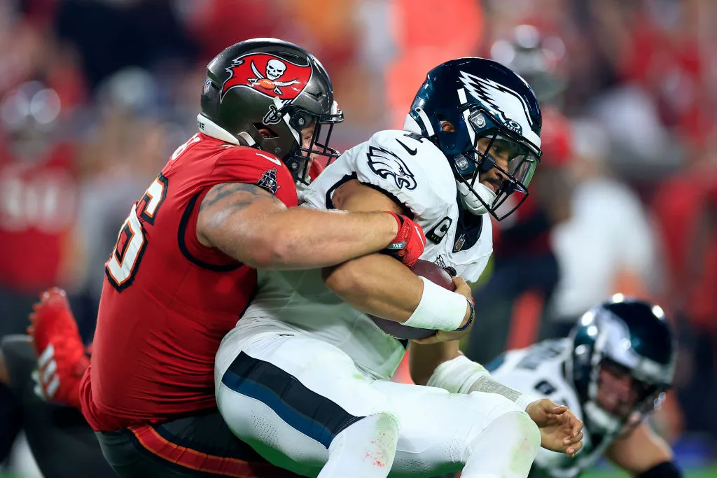 TAMPA, FLORIDA - JANUARY 15: Greg Gaines #96 of the Tampa Bay Buccaneers sacks Jalen Hurts #1 of the Philadelphia Eagles during the fourth quarter in the NFC Wild Card Playoffs at Raymond James Stadium on January 15, 2024 in Tampa, Florida.