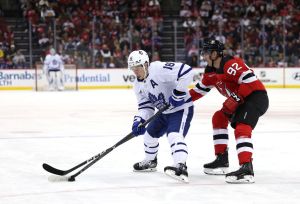 Mitch Marner #16 of the Toronto Maple Leafs takes the puck as Tomas Nosek #92 of the New Jersey Devils defends during the first period at Prudential Center on April 09, 2024 in Newark, New Jersey.