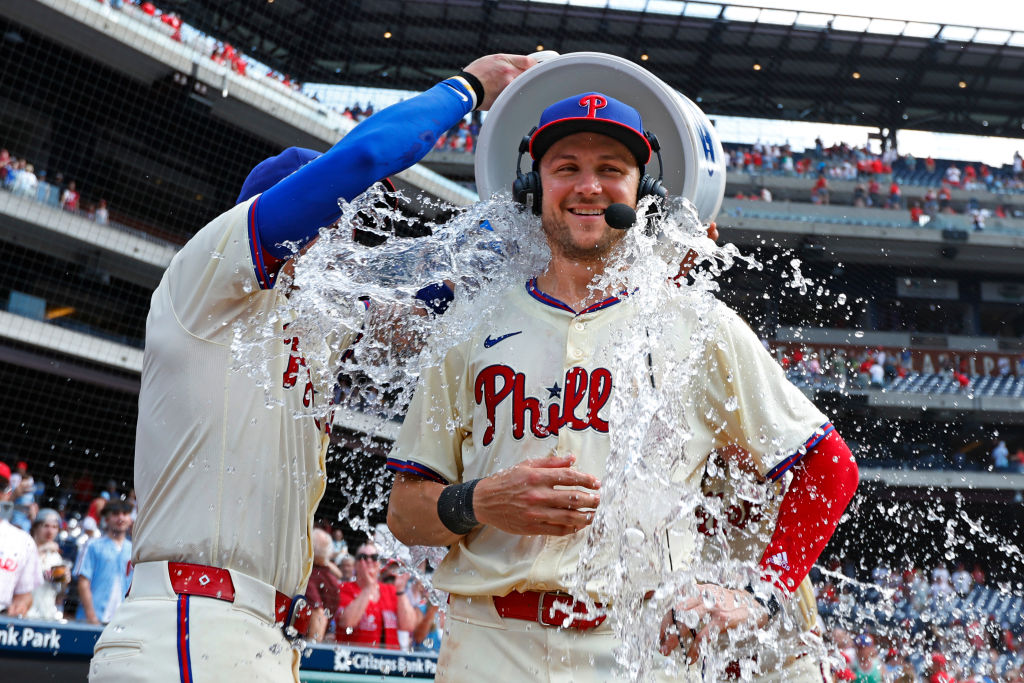 PHILADELPHIA, PENNSYLVANIA - JUNE 30: Trea Turner #7 of the Philadelphia Phillies is doused by water from Bryson Stott #5 and Brandon Marsh #16 after defeating the Miami Marlins 7-6 in a game at Citizens Bank Park on June 30, 2024 in Philadelphia, Pennsylvania.