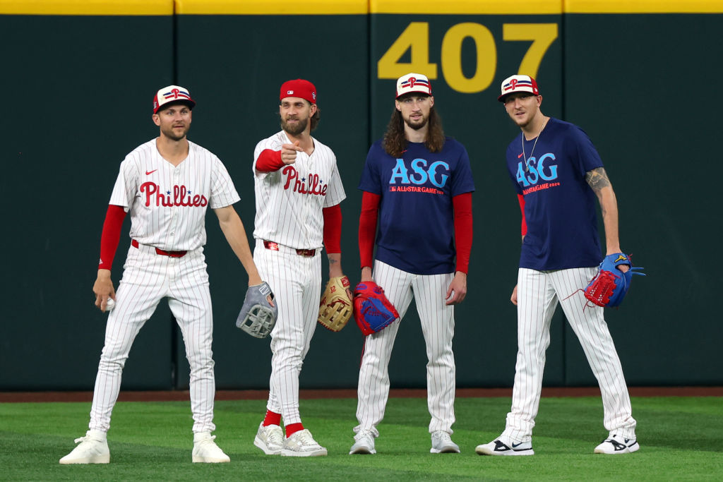 ARLINGTON, TEXAS - JULY 15: (L-R) Trea Turner #7, Bryce Harper #3, Matt Strahm #25 and Jeff Hoffman #23 of the Philadelphia Phillies look on from the outfield during Gatorade All-Star Workout Day at Globe Life Field on July 15, 2024 in Arlington, Texas. 2024 MLB All-Star Game