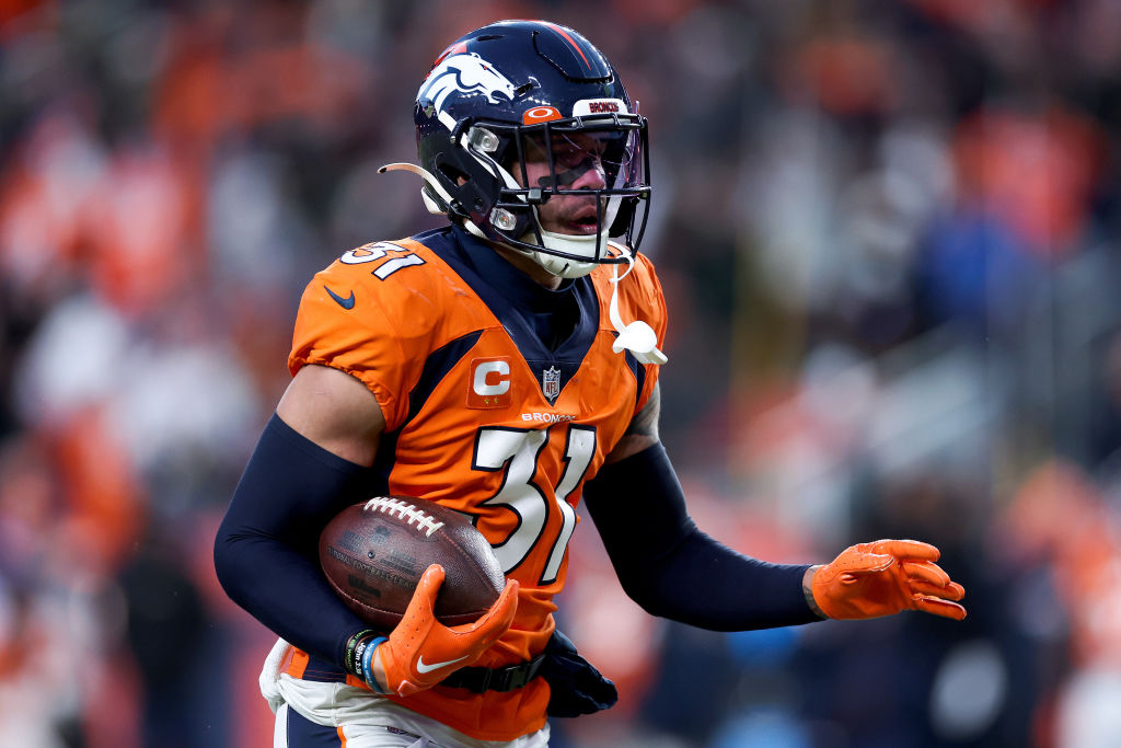 DENVER, COLORADO - DECEMBER 18: Justin Simmons #31 of the Denver Broncos carries the ball after an interception against the Arizona Cardinals during the third quarter of the game at Empower Field At Mile High on December 18, 2022 in Denver, Colorado. The Eagles