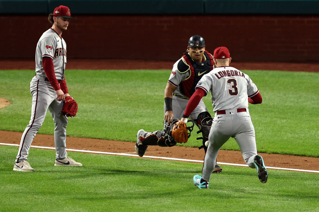 Evan Longoria #3, Gabriel Moreno #14 and Ryne Nelson #19 of the Arizona Diamondbacks react to a ball that drops in for a hit in the seventh inning while playing the Philadelphia Phillies during Game Two of the Championship Series at Citizens Bank Park on October 17, 2023 in Philadelphia, Pennsylvania.