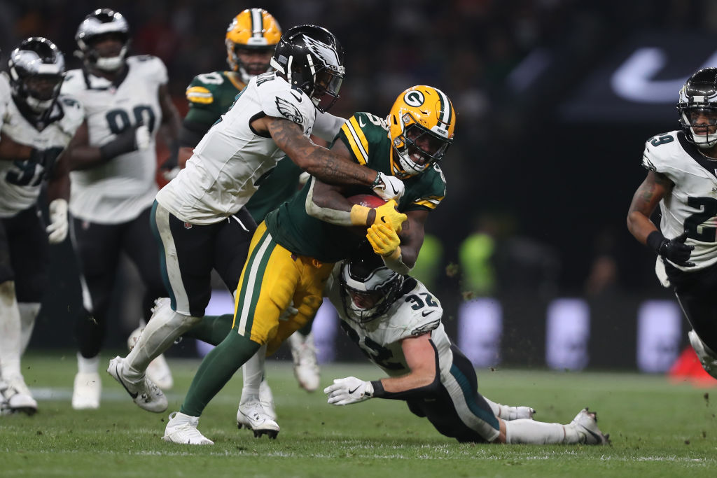 SAO PAULO, BRAZIL - SEPTEMBER 06: Josh Jacobs #8 of the Green Bay Packers is tackled by Reed Blankenship #32 and Darius Slay Jr. #2 of the Philadelphia Eagles during the fourth quarter at Arena Corinthians on September 06, 2024 in Sao Paulo, Brazil. 