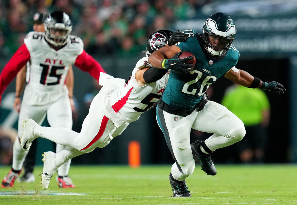 PHILADELPHIA, PENNSYLVANIA - SEPTEMBER 16: Saquon Barkley #26 of the Philadelphia Eagles runs with the ball against Kaden Elliss #55 of the Atlanta Falcons during the third quarter in the game at Lincoln Financial Field on September 16, 2024 in Philadelphia, Pennsylvania.